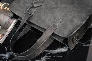 Close-up detail of grey PU leather tote bag texture, premium shoulder handbag craftsmanship.