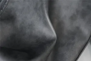 Close-up detail of premium grey faux leather material with fine vintage texture and zipper.