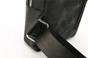 Close-up detail of black camouflage men chest bag strap buckle and durable metal hardware.