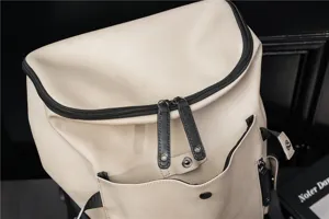Vista dettagliata dell'elegante zaino da uomo in pelle beige con cerniera nera e tasca.