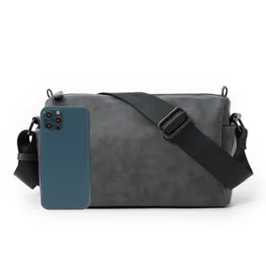 Dark gray cylinder shoulder bag detail, featuring durable fabric and adjustable black strap.