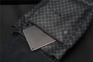 Detailed view of the black monogram pattern backpack featuring a front pocket and durable fabric.