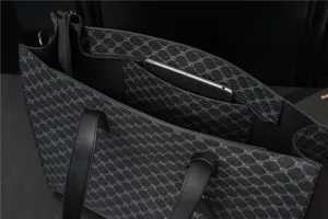 Interior view of black PU leather tote bag, showing spacious compartment and zipper pocket.