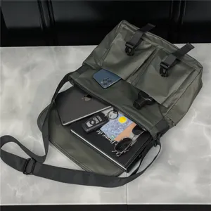 Detail view of dark green waterproof oxford messenger bag showing inside capacity and buckles.