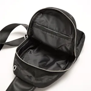 Black camo sling bag detail view, showing interior pocket, smooth zipper and strap.