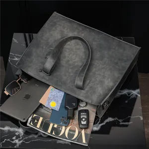 Detail view of large capacity dark grey PU leather tote bag with tablet and daily essentials inside.