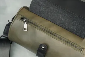 Detailed view of the green cylindrical shoulder bag zipper and black strap components.