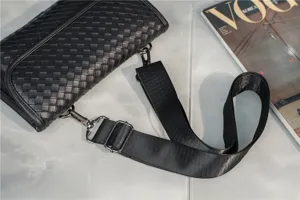 Detailed close-up view of black woven leather shoulder bag, adjustable strap and metal hardware.