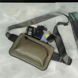 Detailed view of stylish green men's chest bag with practical front pocket and adjustable strap.