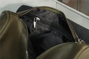 Vintage green leather barrel bag interior detail, featuring secure zipper pocket and lining.