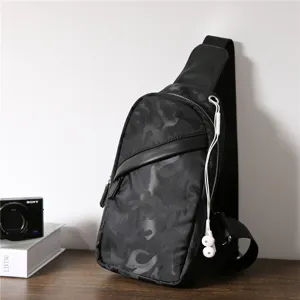Detailed close-up of the stylish black camo sling bag on a wooden surface with scene props.