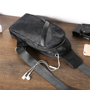 Camouflage chest bag detail view, showing headphone hole and adjustable shoulder strap.