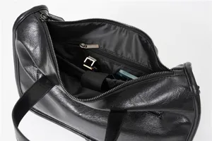Dettaglio interno della borsa a tracolla nera da uomo in pelle con tasca e ampio spazio.