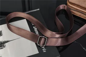 Vintage bruine heren schoudertas riem detailopname, duurzame stof en metalen gesp.