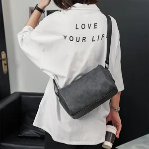 Stylish men's cylindrical shoulder bag in dark grey leather for daily casual wear and style.