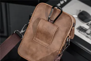 Retro PU lederen telefoontas detail met karabijnhaak, riemclip en verstelbare schouderriem.