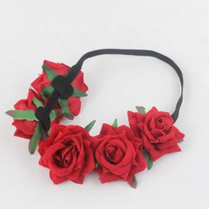 Close-up detail of red rose flower headband with black elastic band for party hair decor.