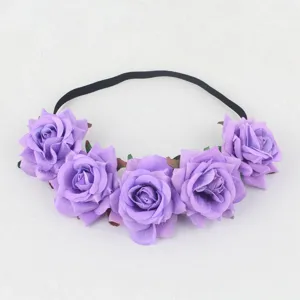Closeup view of purple rose floral headband with black elastic band for party hair decor.