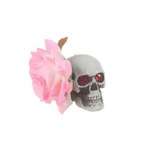 Vue détaillée de la rose rose gothique et de la pince à cheveux tête de mort aux yeux de cristal.