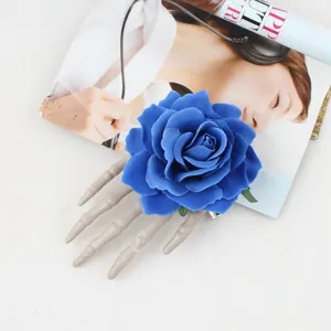 Detail view of Halloween skeleton hand hair clip featuring blue rose for party costume accessory.