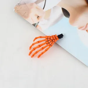 Dettaglio molletta per capelli a scheletro di Halloween, design artiglio arancione.