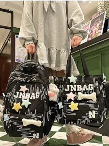 Casual black waterproof nylon backpack and handbag set with cute plush star and bone decorations.