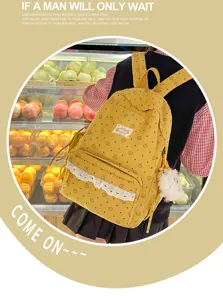 Detailed view of yellow corduroy backpack with cute floral embroidery, lace trim and pendant.