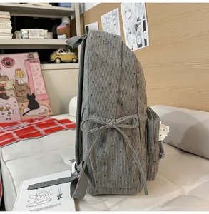Grey corduroy backpack side view, cute floral pattern schoolbag with lovely bowknot detail.