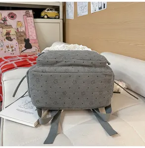Corduroy floral backpack detail showing cute lace trim and grey fabric texture for students.