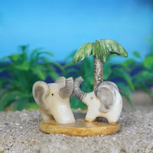 Primo piano di simpatiche statuine di mini elefanti per arredamento da tavolo in sabbia.