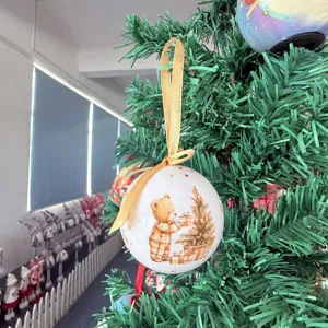 Weihnachtskugel Ornament mit süßem Teddybär und Baummotiv zum Aufhängen mit goldenem Band.