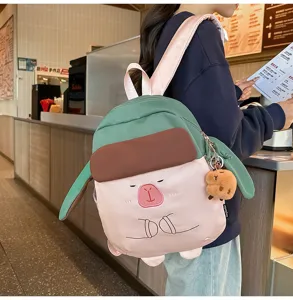 Zaino capybara carino con cappello divertente, borsa verde e rosa creativa per viaggi e tempo libero.