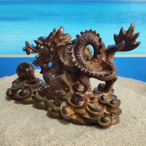 Detailed view of Chinese dragon tea pet figurine resting on gold sycee coins for fortune.