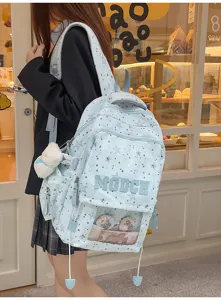 Vue détaillée du sac à dos bleu clair motif étoiles avec fenêtre transparente et pendentif.