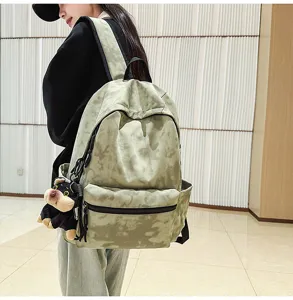 Detailed shot of the stylish tie-dye canvas backpack with cute puppy pendant.