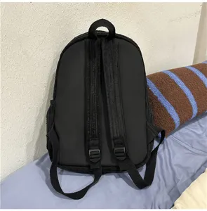 Detailed back view of a solid black corduroy backpack showing adjustable shoulder straps.