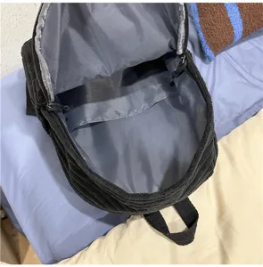 Black corduroy backpack inner structure and zipper pocket detail close-up presentation.