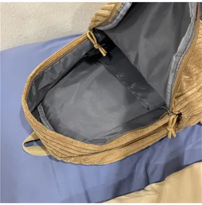 Detailed interior view of a solid color corduroy backpack, showing ample storage space.