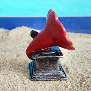 Modèle de gramophone vintage miniature, pavillon rouge, gros plan de jouet de bac à sable.