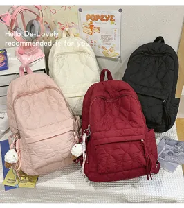Vue détaillée du sac à dos matelassé en coton aux multiples coloris, texture douce et poche avant.