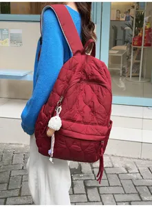 Vue détaillée du sac à dos matelassé élégant avec joli porte-clés en scène urbaine.
