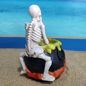 Halloween skeleton resin ornament detail, spooky cauldron design, perfect for desktop decor and parties.