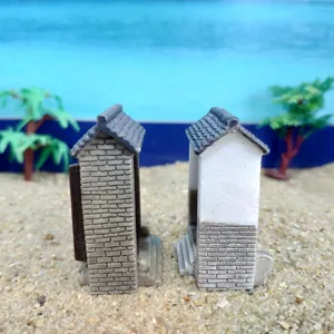 Detailed miniature building models closeup showcasing traditional grey brick and white walls.