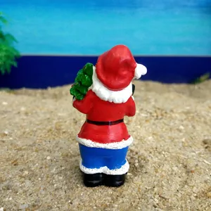 Detailed close-up view of a miniature Santa Claus resin figurine on sand tray backdrop.