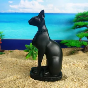 Detailed view of a black Egyptian Bastet cat resin statue ornament on sand background.
