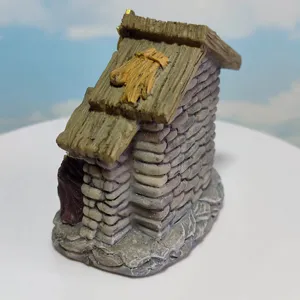 Detailed shot of miniature resin Christmas manger hut figurine, rustic stone wall and roof design.