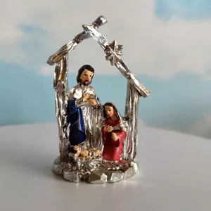 Resin nativity scene figurine detail showing Joseph Mary and baby Jesus in stable frame.