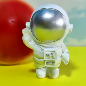 Detail shot of a cute white astronaut figurine with a silver visor, ideal for room decor.