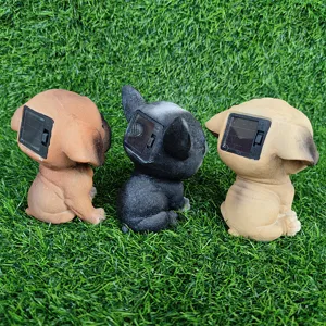 Detailed view of three cute resin dog solar garden lights placed neatly on green turf.
