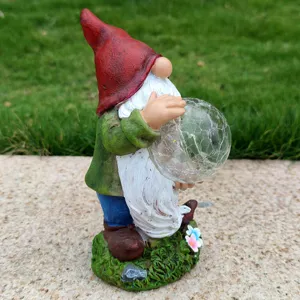 Resin garden gnome statue holding a glowing crackle glass ball, outdoor yard lawn landscape decor.